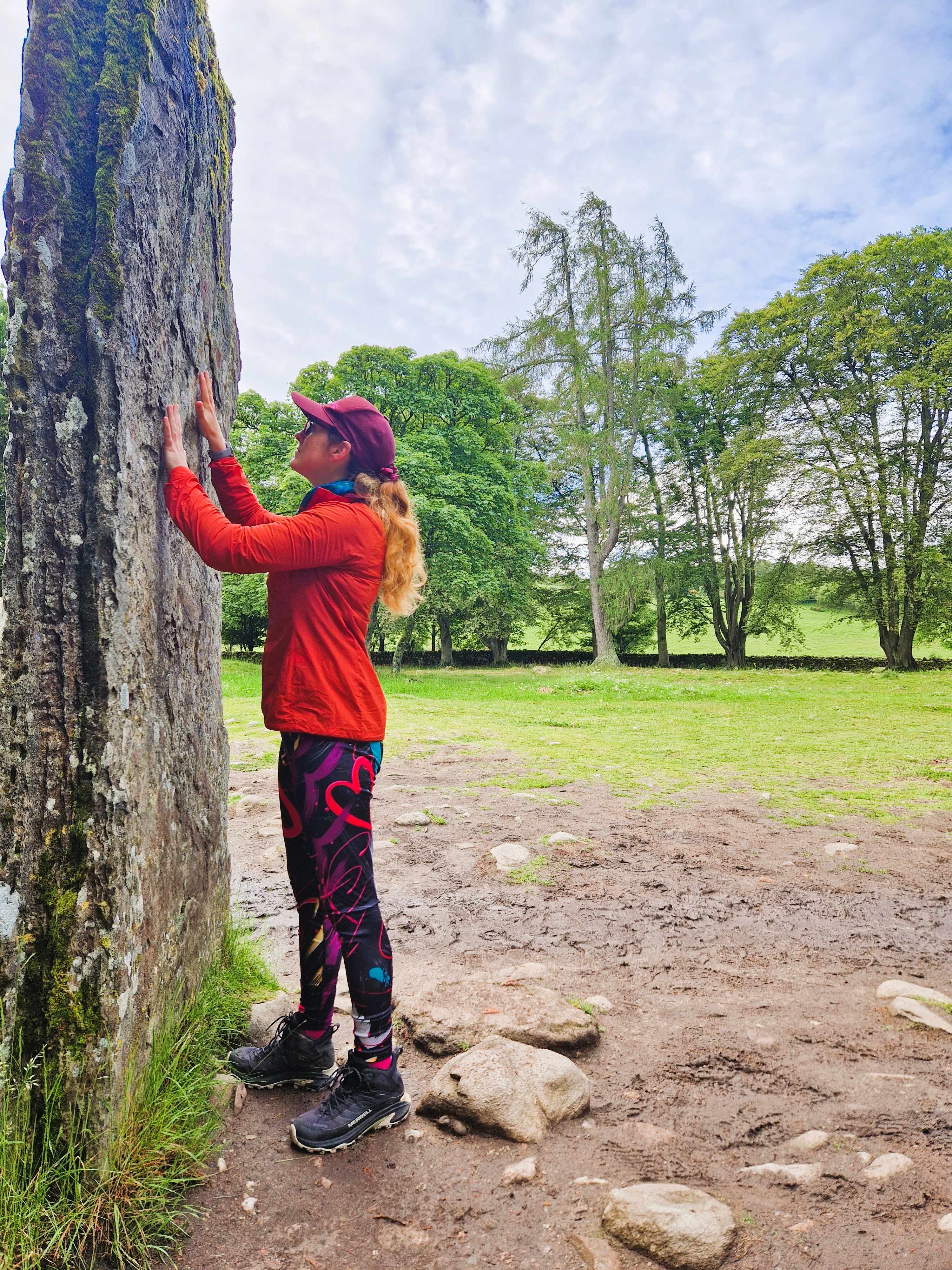 LeahinWanderlust touching the standing stones at Clava Cairns
